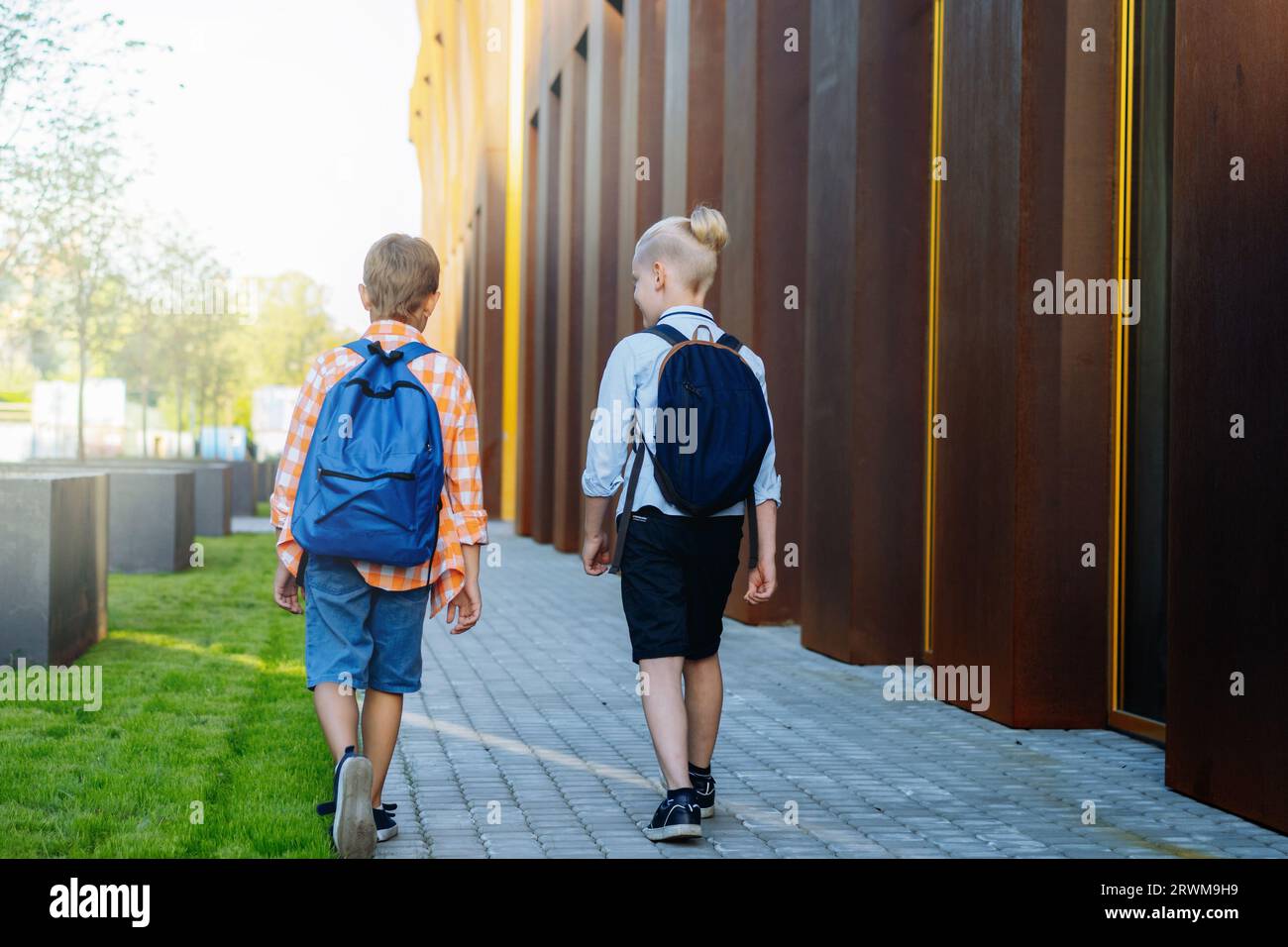 children go to school with backpacks on sunny day. Begining of academic ...