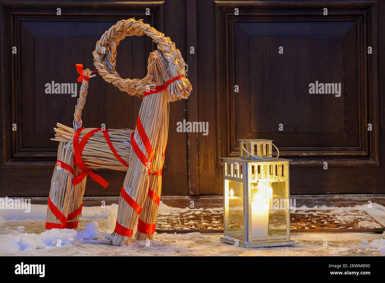 Christmas goat and lantern in front of door Stock Photo