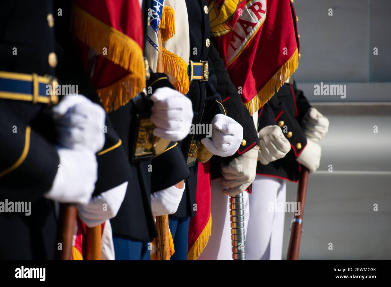 A close-up shot of the hands of armed soldiers marching in formation Stock Photo