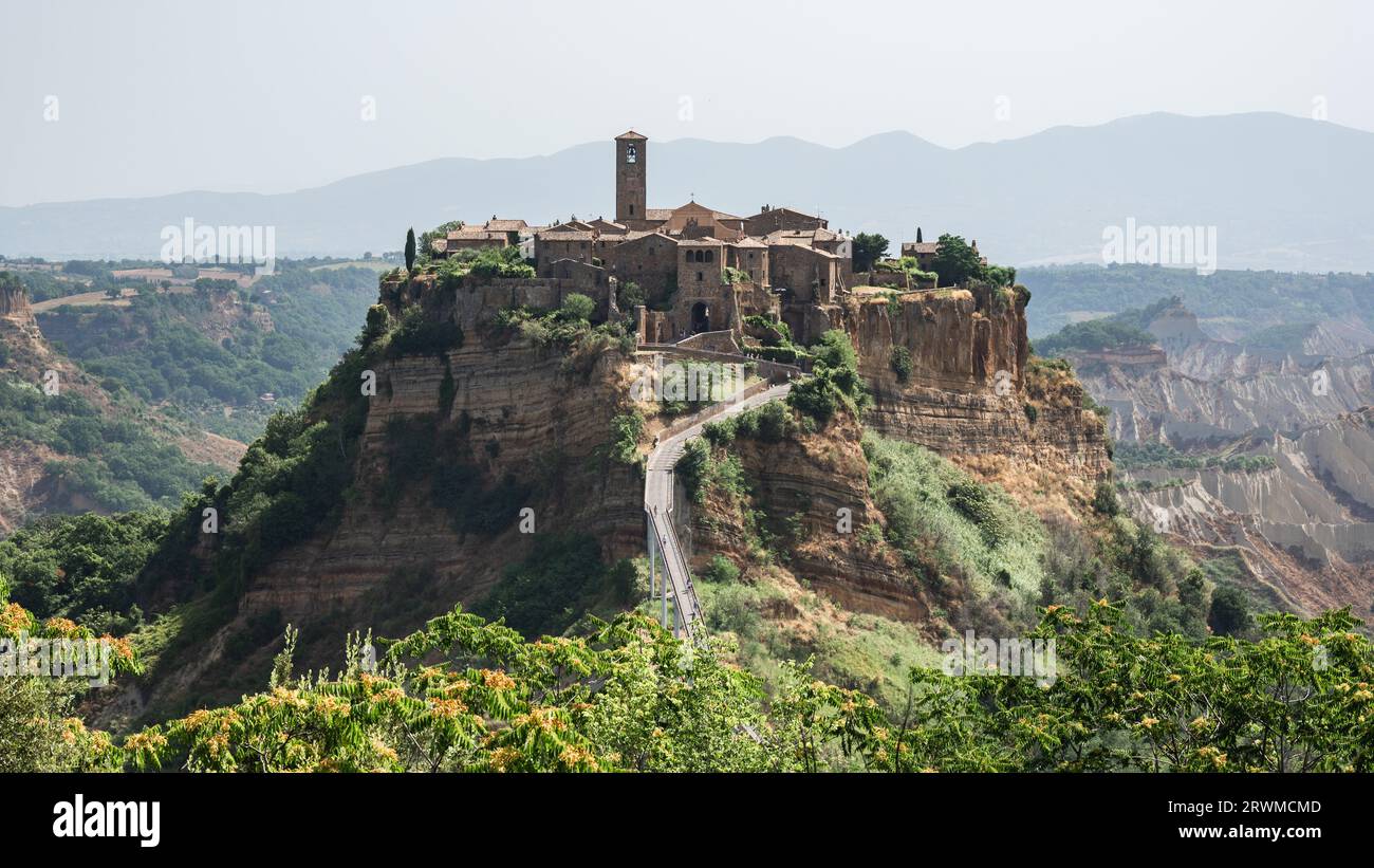 An impressive stone castle is perched atop a mountain overlooking a ...