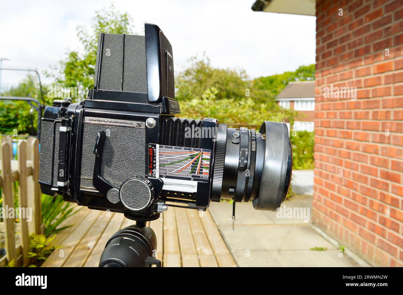 Medium format camera mounted on a tripod outside on decking Stock Photo