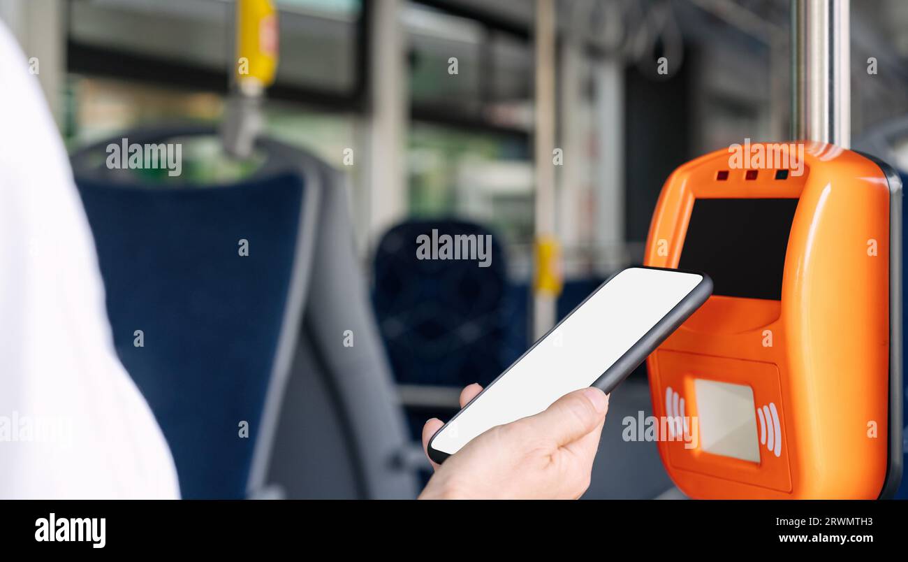 Mobile payment concept, smart phone with empty screen in females hand pays bus travel using contactless technology of phone. Stock Photo