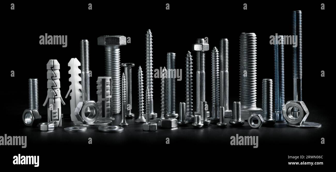 screws, bolts and fasteners isolated on black background. banner Stock Photo