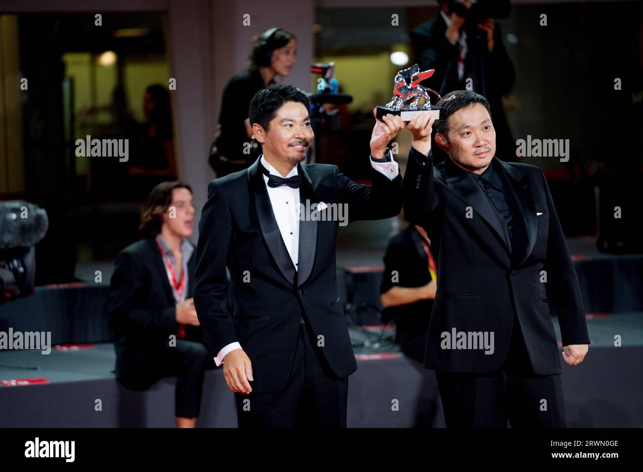 VENICE, ITALY - SEPTEMBER 09: Hitoshi Omika and Ryûsuke Hamaguchi pose with the Silver Lion Grand Jury Prize Award for 'Evil Does Not Exist' on stage Stock Photo
