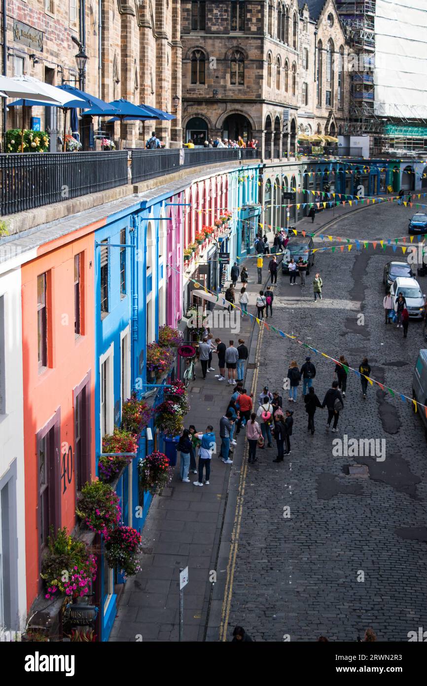 Looking Up West Bow Street filled with colourful shop fronts in the City of Edinburgh, Scotland. Stock Photo