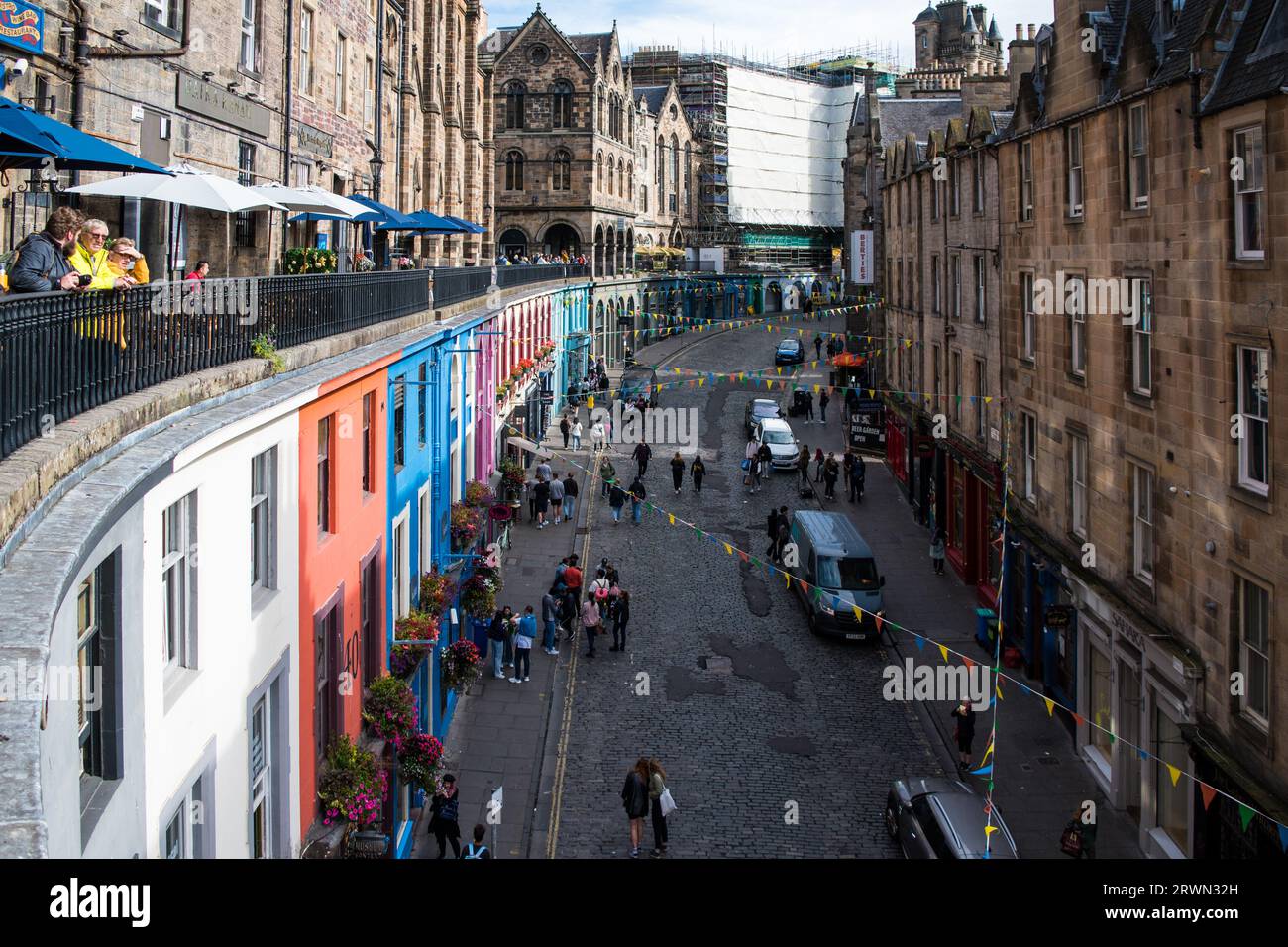 looking Up West Bow Street filled with colourful shop fronts in the City of Edinburgh, Scotland. Stock Photo