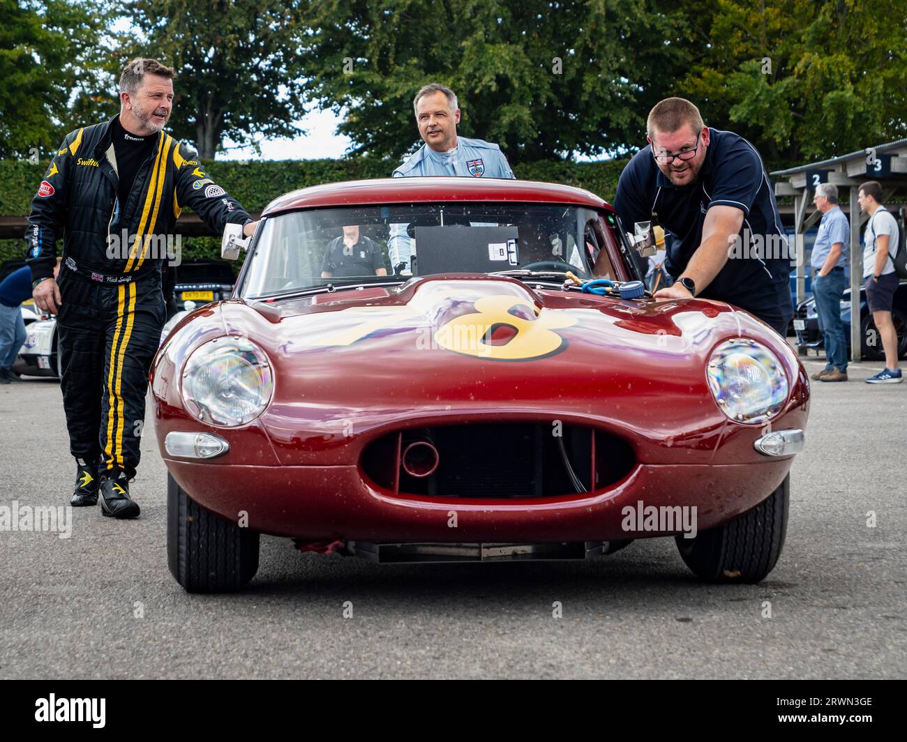 Andy Priaulx and Nick Swift pushing a racing E type Jaguar on a testing day at the Goodwood motor racing circuit, West Sussex UK 2023 Stock Photo