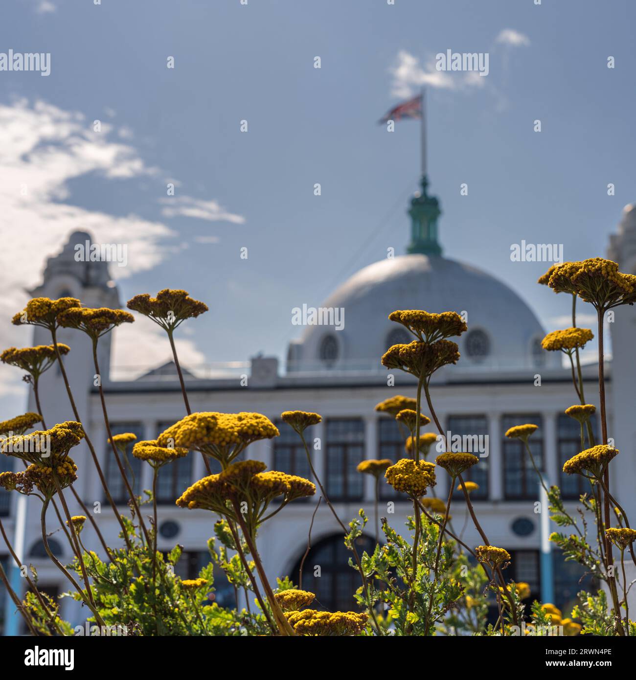 The white dome and towers of Spanish City, Whitley Bay in North Tyneside with flowers and foliage in the foreground Stock Photo