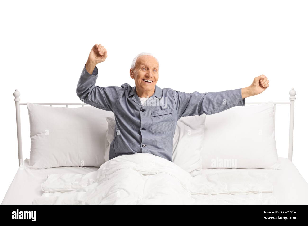 Happy elderly man stretching in a comfortable bed isolated on white background Stock Photo Alamy