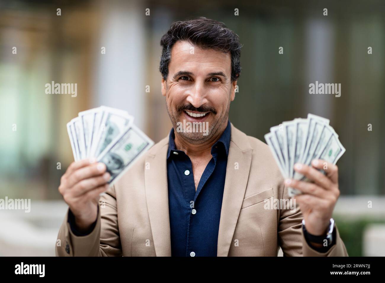 Cash money dollar banknotes in happy middle eastern businessman hand Stock Photo