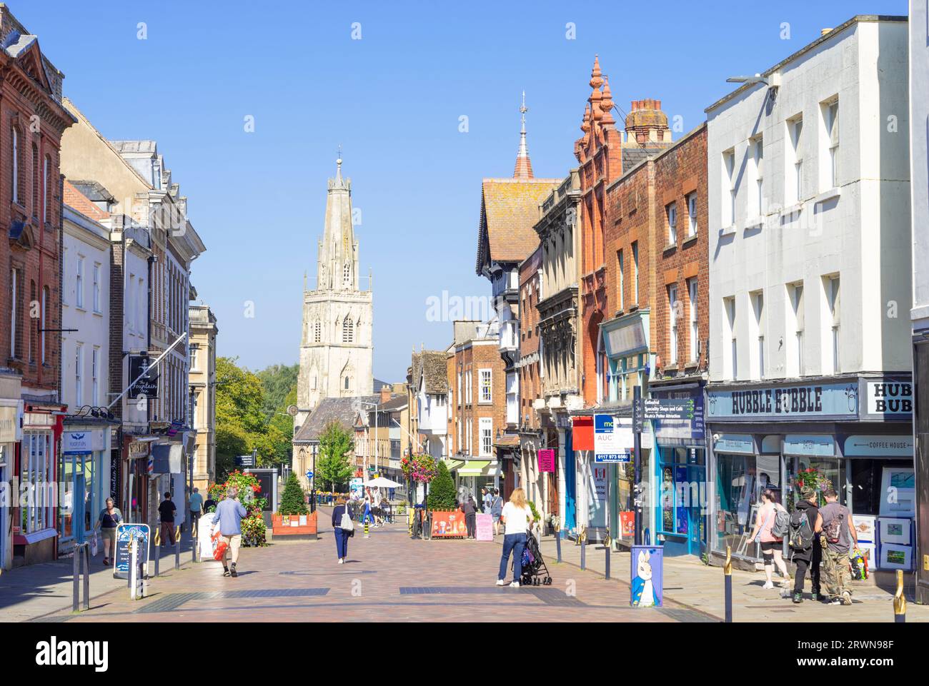 Gloucester city centre pedestrianised Westgate street with shops and people shopping and St Nicholas church spire Gloucestershire England UK GB Europe Stock Photo