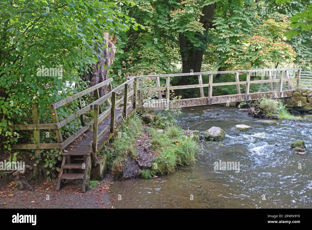 Footbridge over river at Beresford Dale, Peak district, Derbyshire Stock Photo