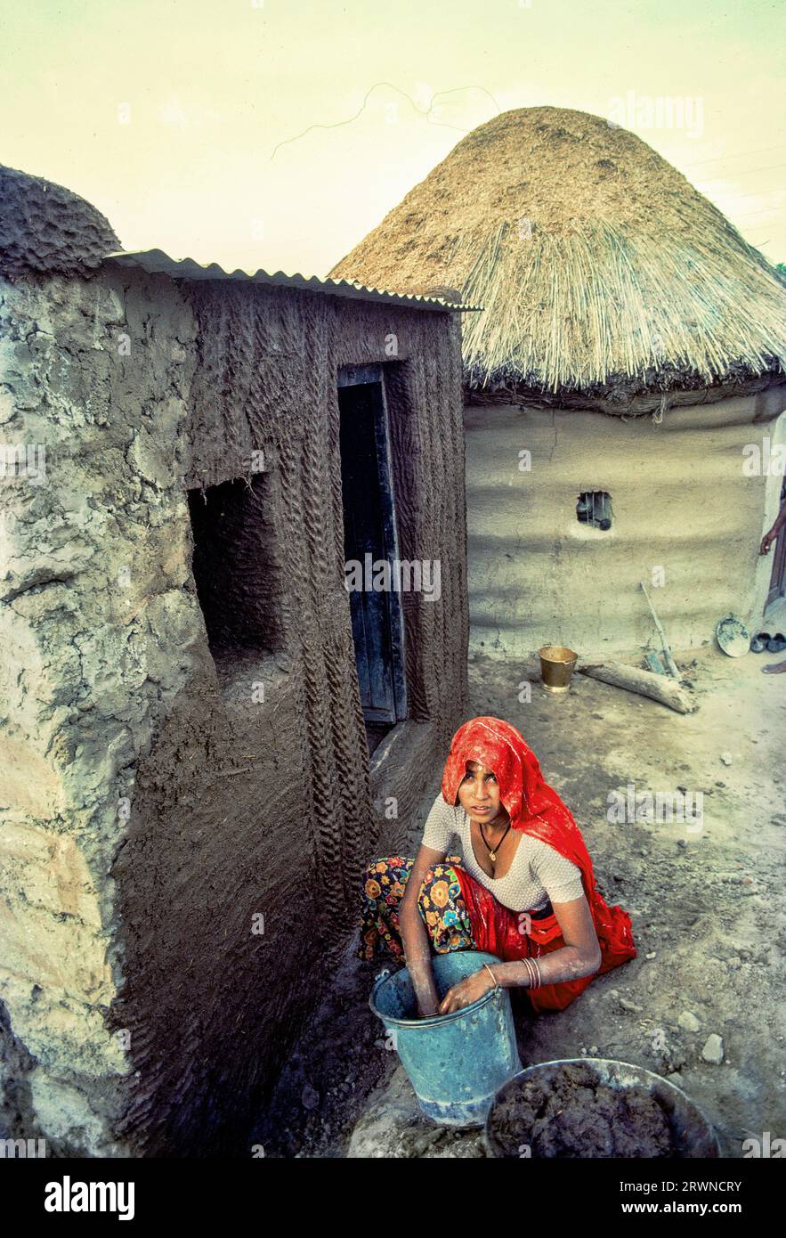 04 03 2020 woman applying Mud and cow dung plaster on house wall Sri ...