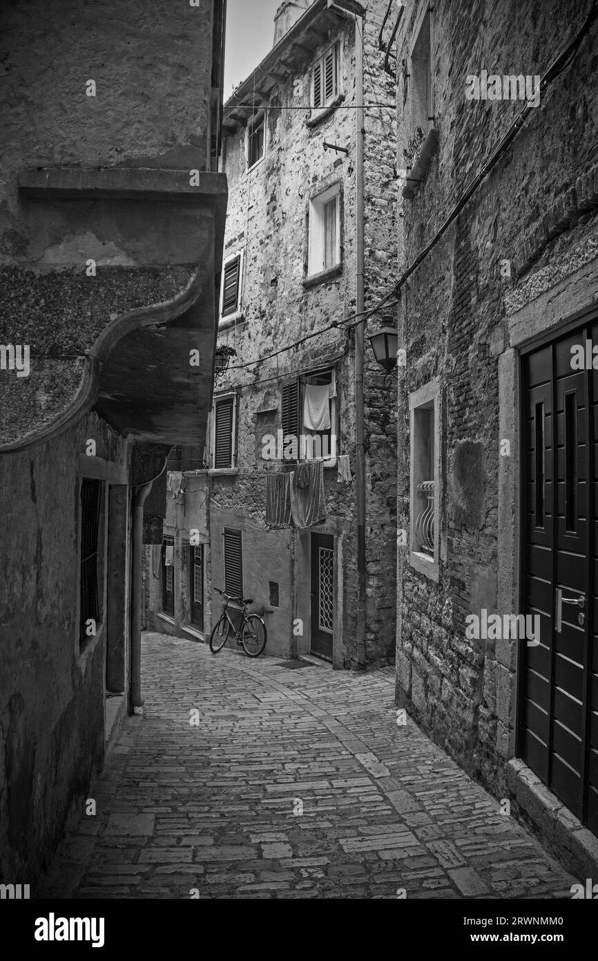 A quiet street in the historic centre of the medieval coastal town of Rovinj, Istria, Croatia. The building front left has jettying with arch support Stock Photo