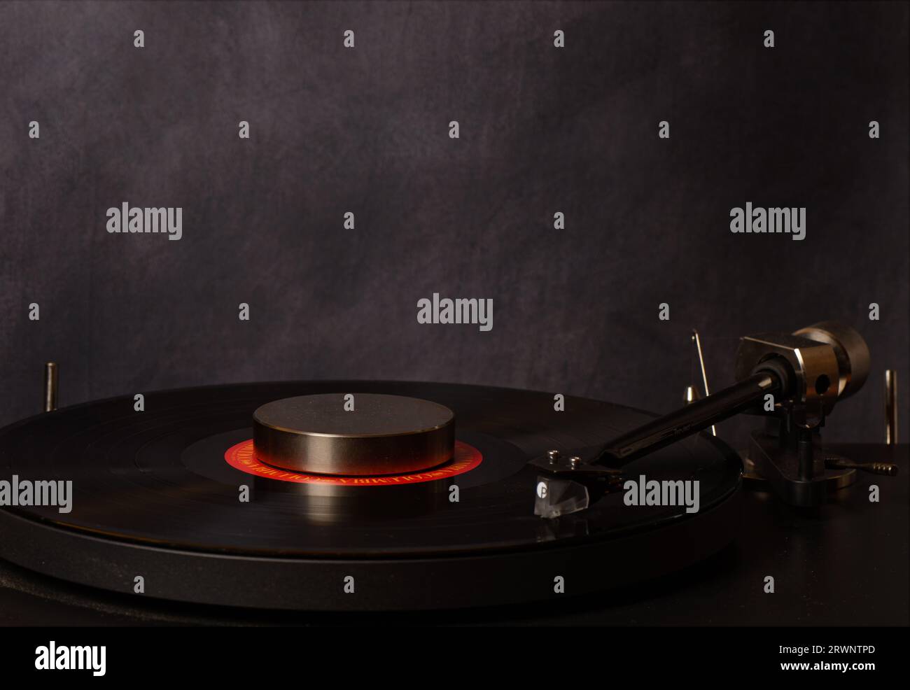 Pro-ject Debut Pro turntable and tone arm with heavy duty vinyl LP record, weighted puck on the disc. Stock Photo