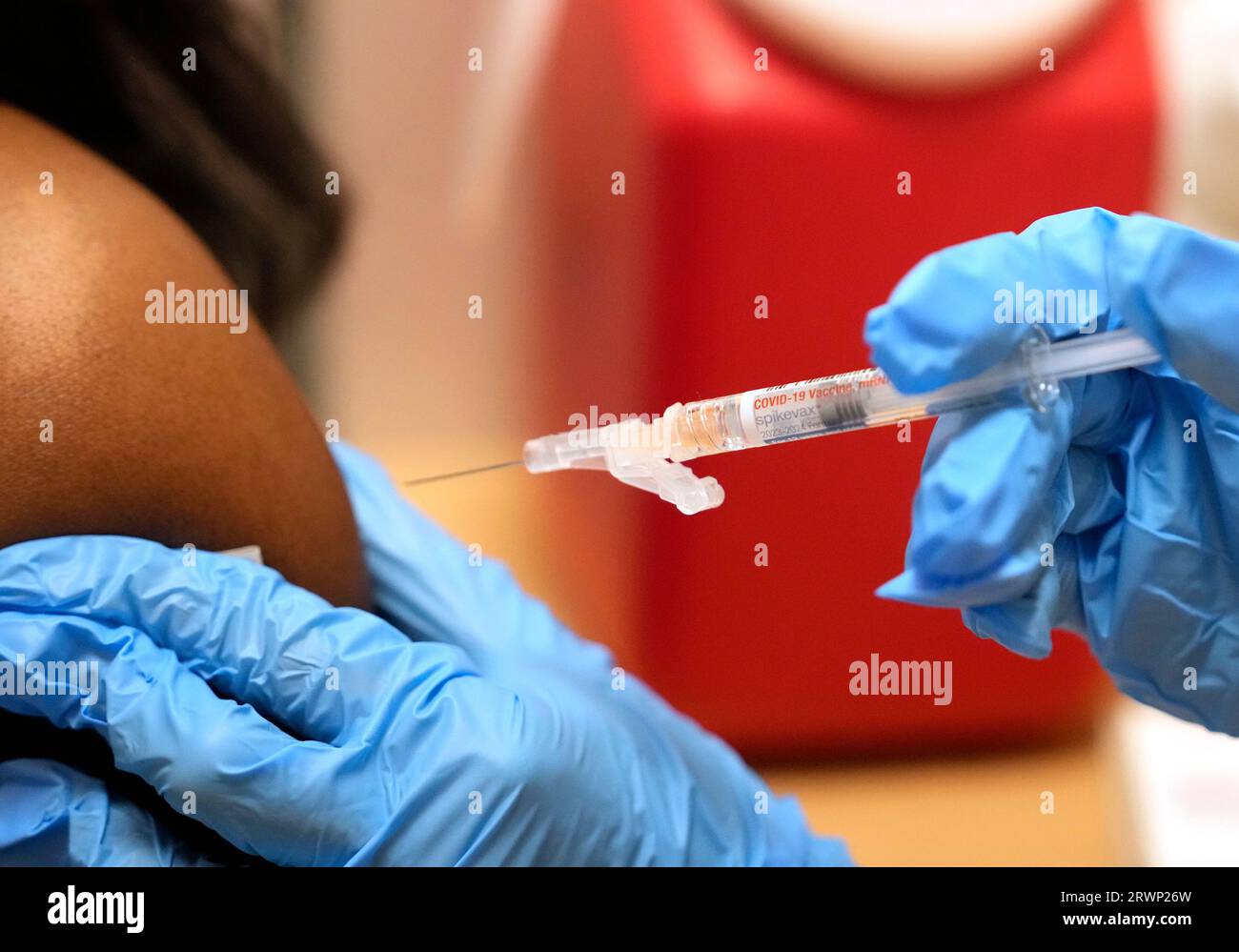 Pharmacist Kim Nguyen administers a Moderna Spikevax COVID-19 vaccine ...