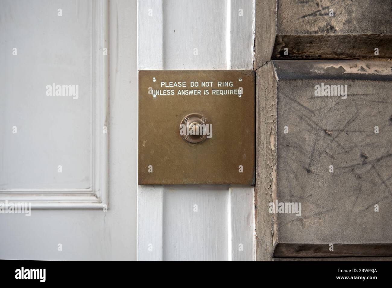 Quirky doorbell sign - Please Do Not Ring Unless Answer Is Required - on a brass by the door of a New Town property in Edinburgh, Scotland, UK. Stock Photo