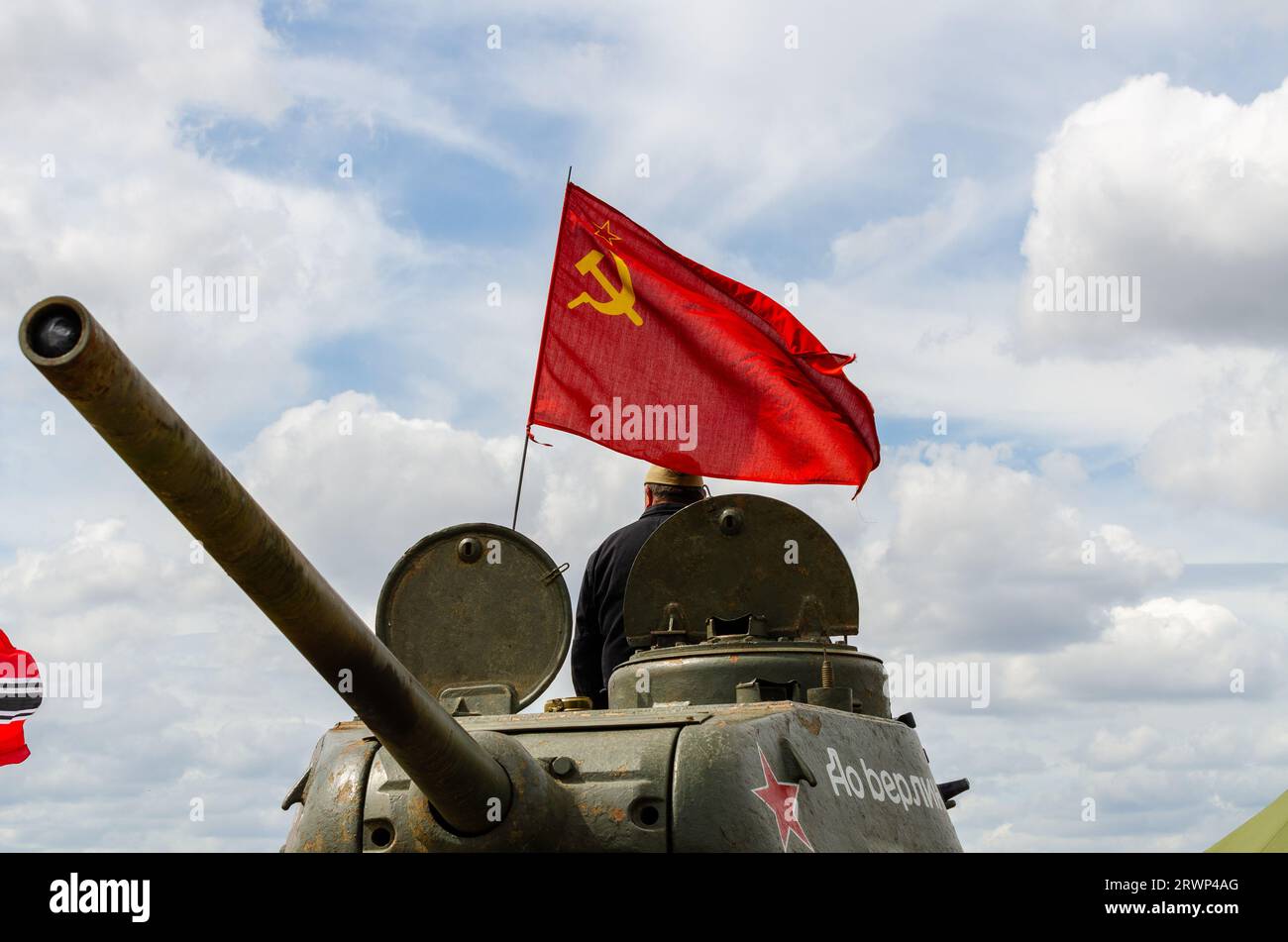 Russian tank flying the hammer and sickle red flag. Second World War T-34 tank at a military re-enactment event in Essex, UK. Red flag flying Stock Photo