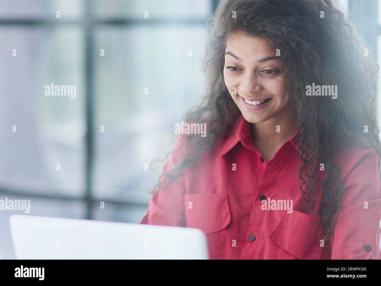 Photo of joyful nice woman using laptop and smiling while sitting Stock ...