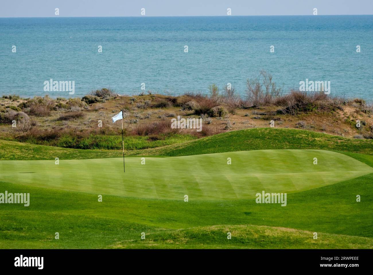 A golf course and its flag pole. Flag pole on a golf green Stock Photo Alamy