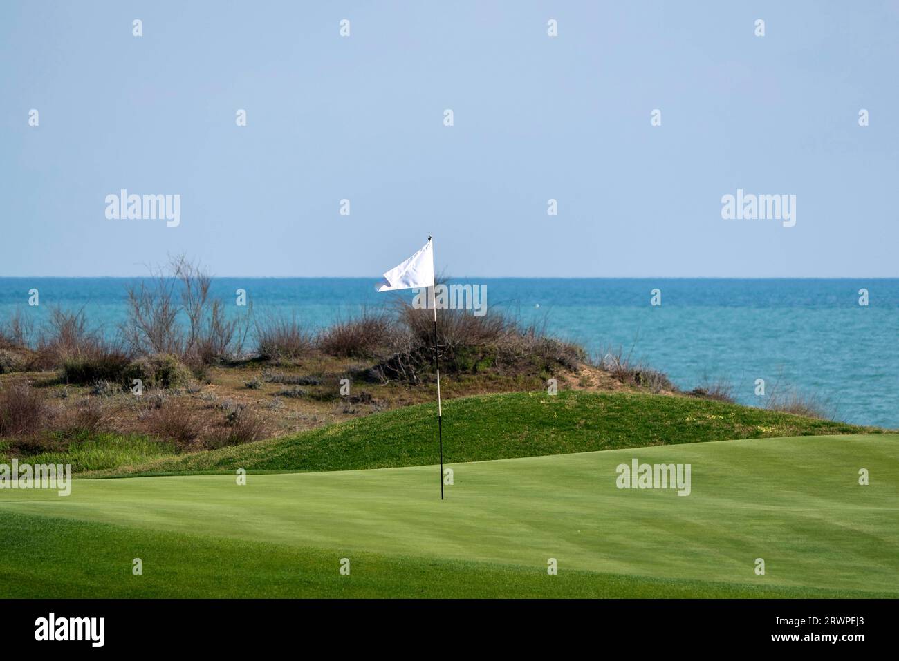 A golf course and its flag pole. Flag pole on a golf green Stock Photo Alamy