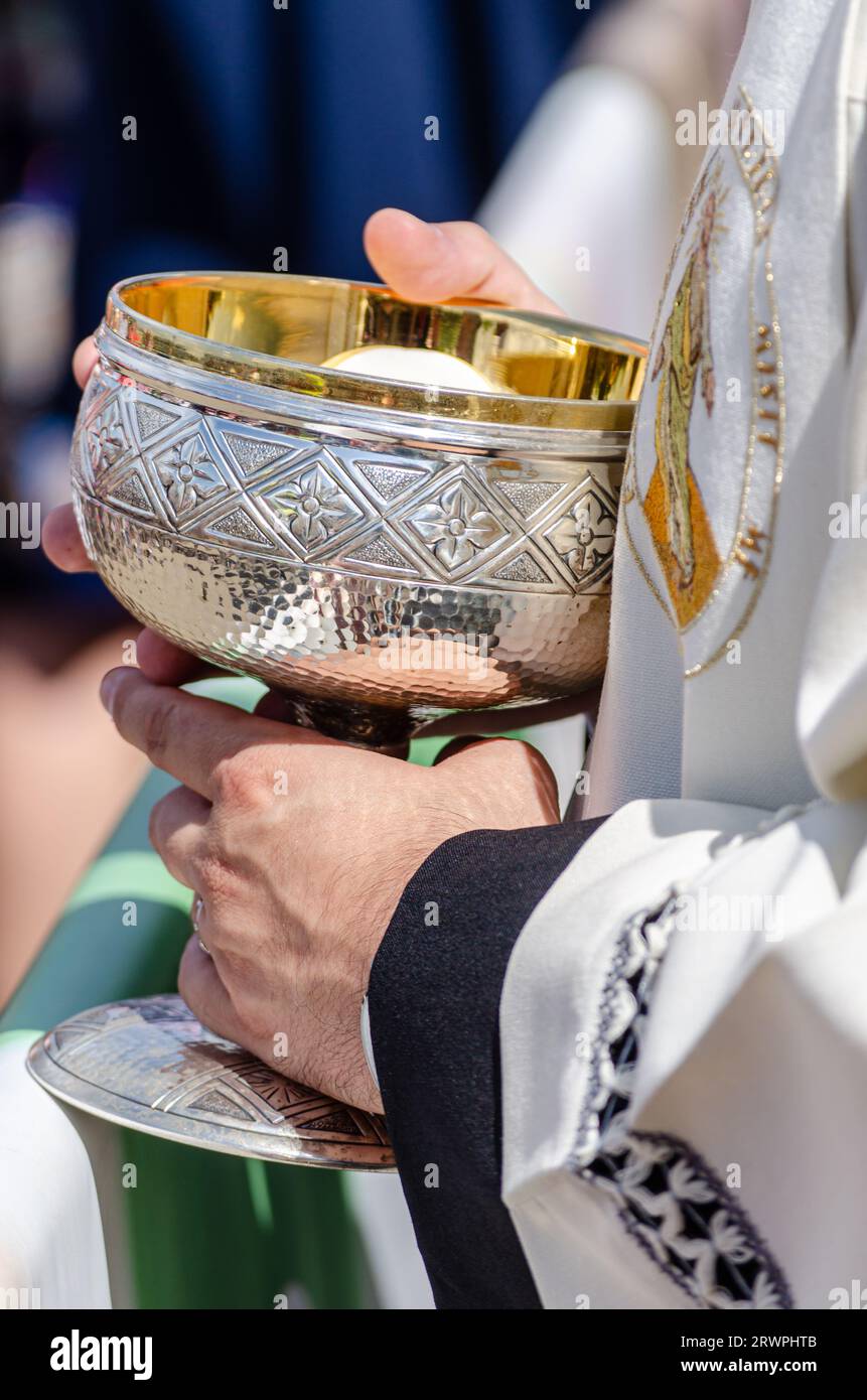 hands of a catholic priest holding a chalice Stock Photo