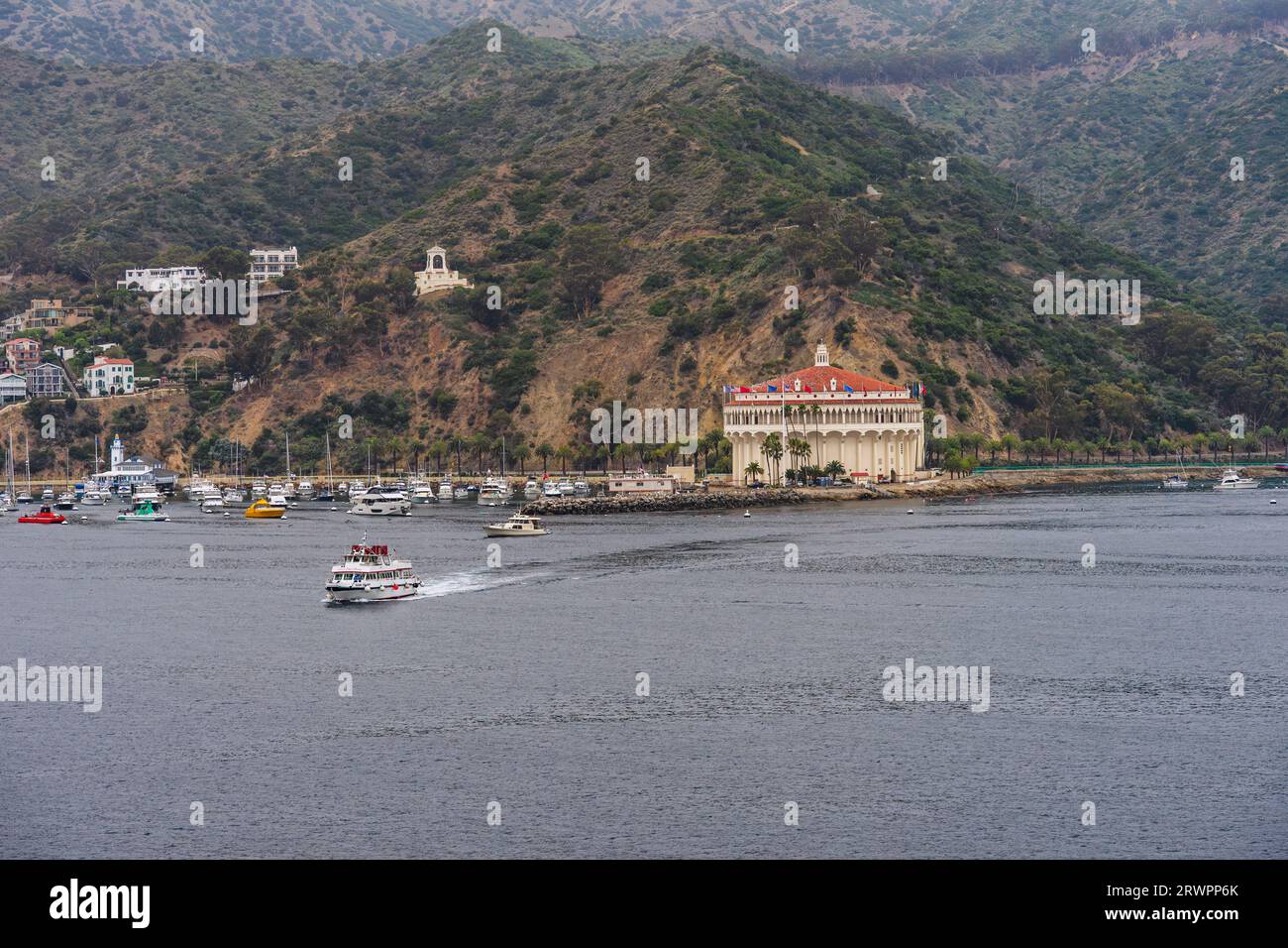 Avalon, CA, USA - September 13, 2023: Avalon Harbor on Santa Catalina Island in the morning with view of the Casino Building and a tender boat heading Stock Photo