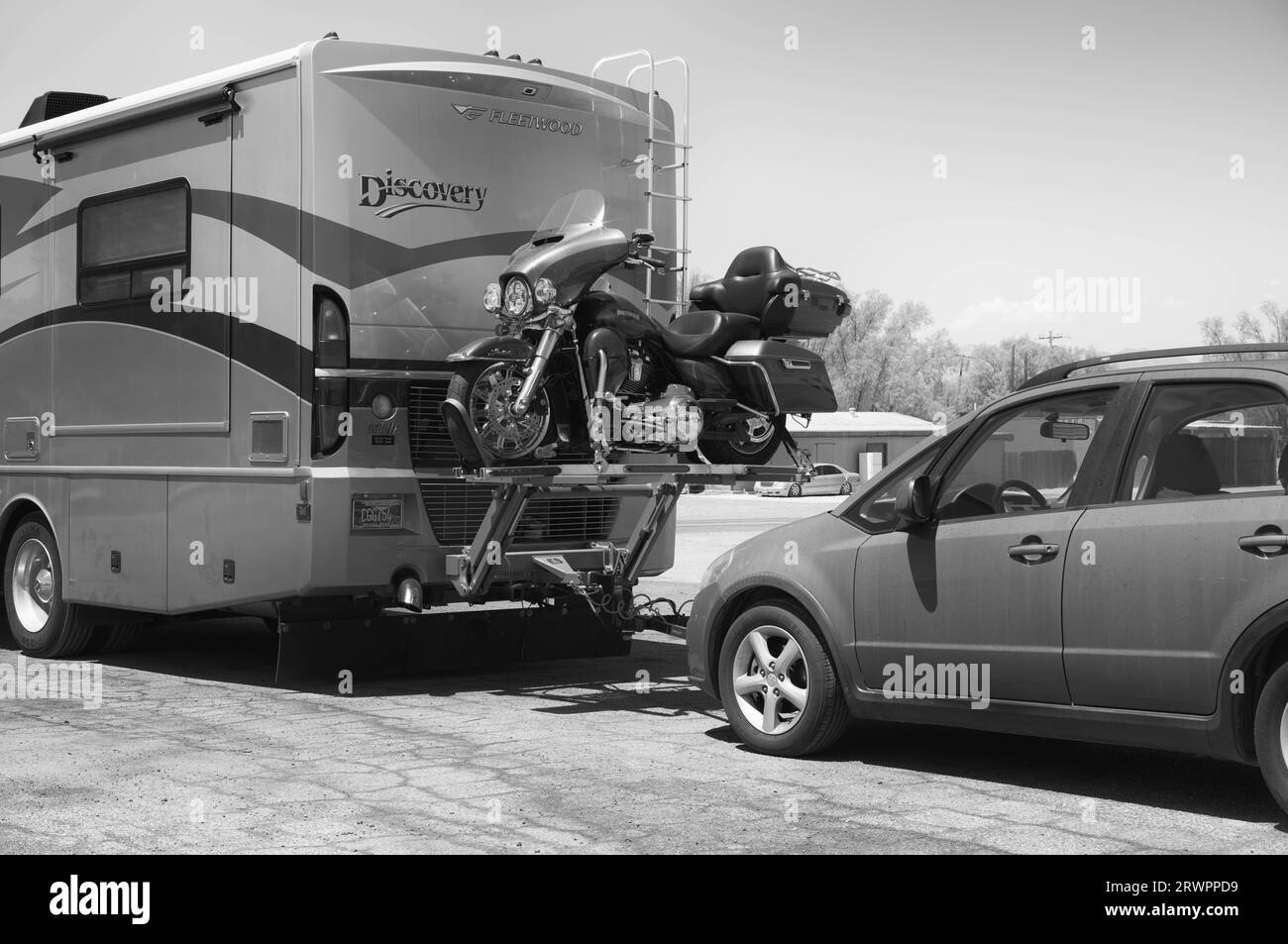 Highway travelers with a motor home, Harley-Davidson Motorcycle and compact car. Stock Photo