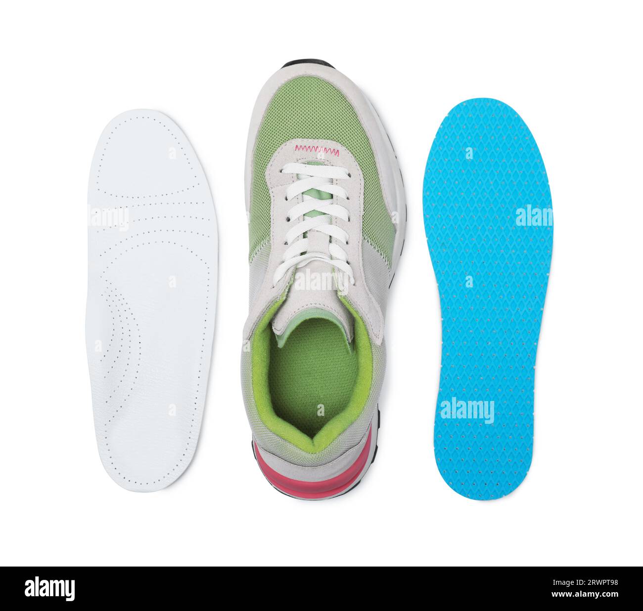 Different orthopedic insoles near shoe on white background, top view