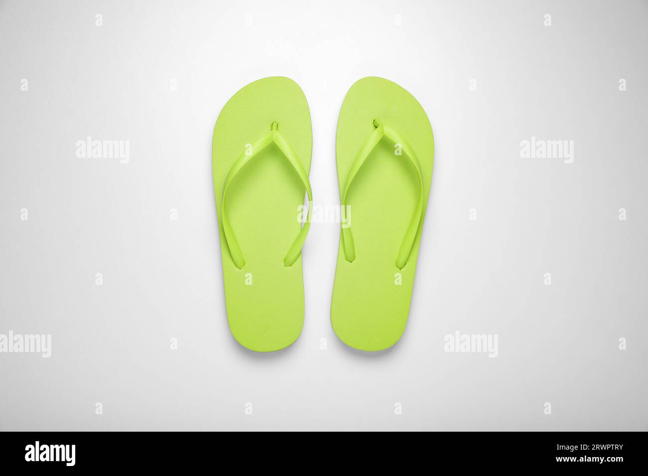 Light green flip flops on white background, top view Stock Photo - Alamy