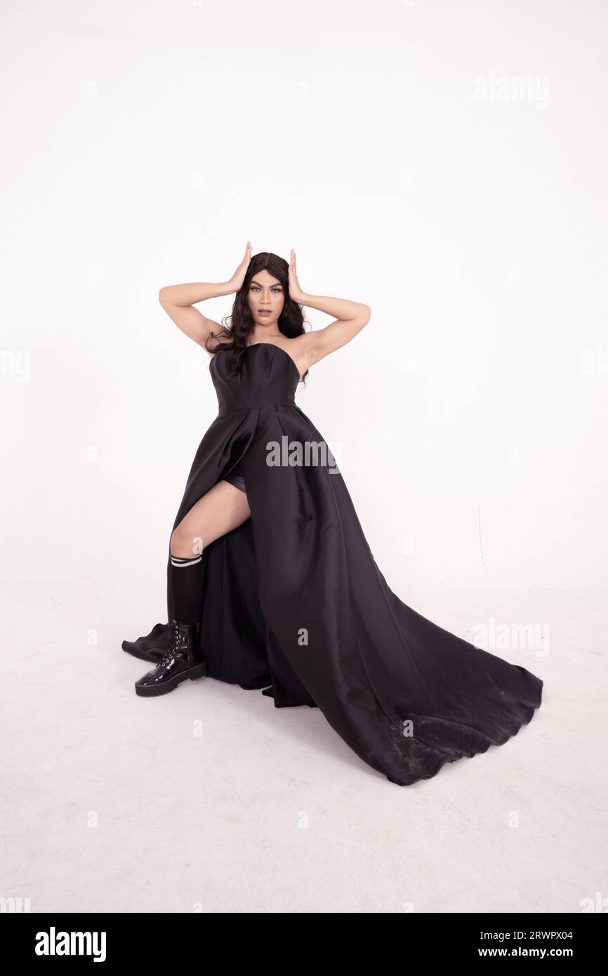 A whole body of an Asian woman in a black dress poses in a white studio with dark brown hair Stock Photo