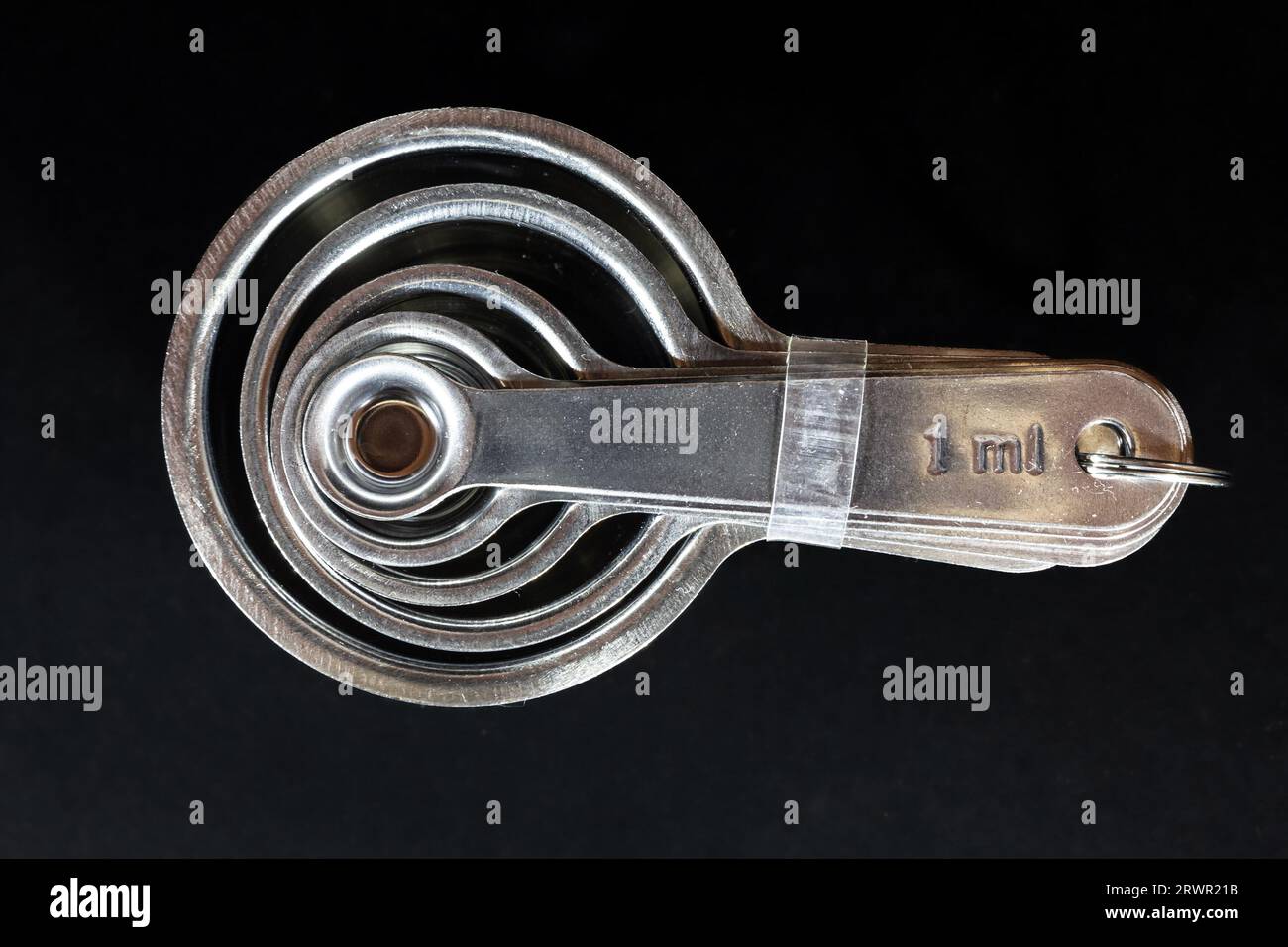 Picture of measuring teaspoons, concentrical, of various quantities, using metric system and