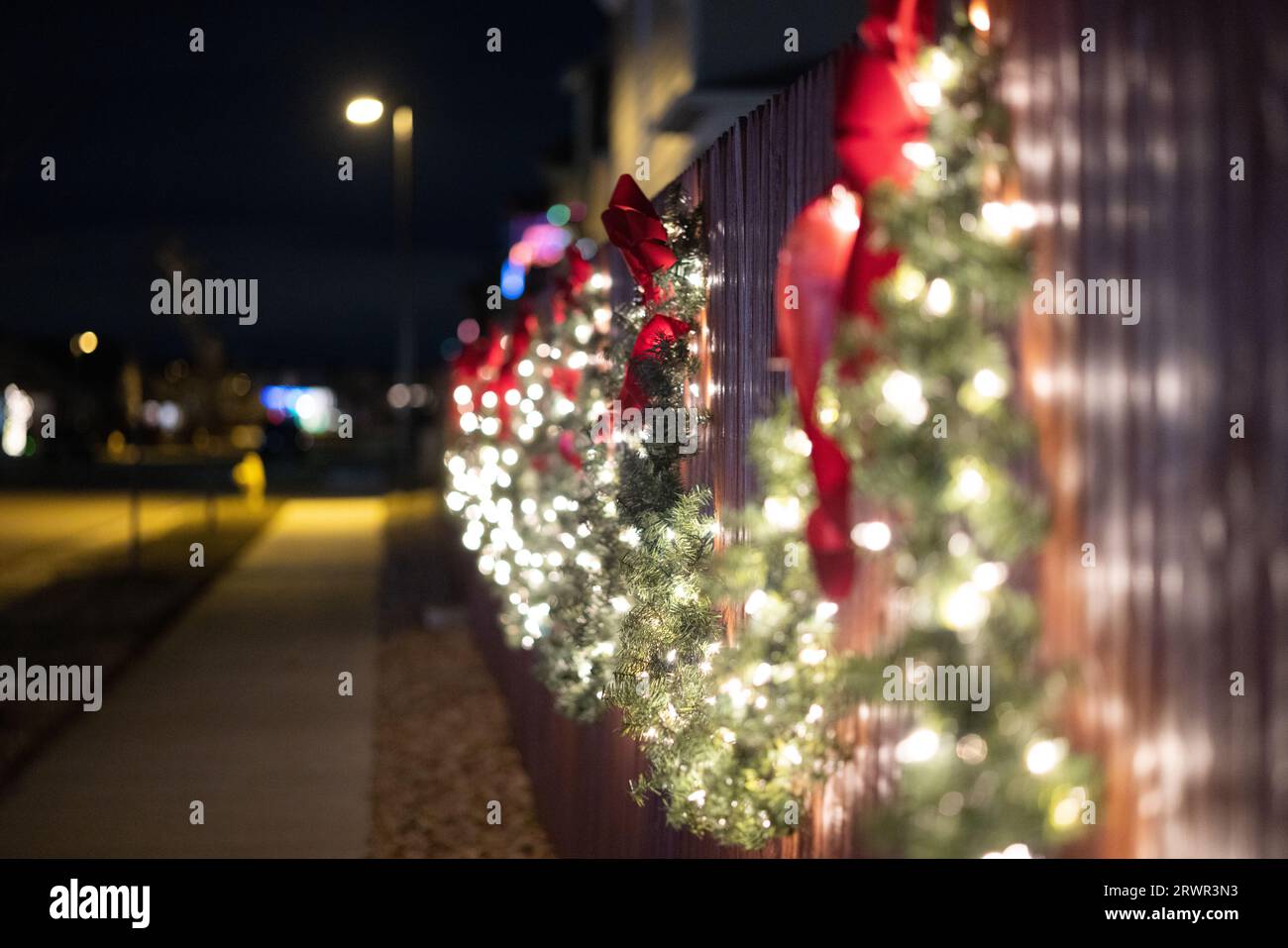 christmas wreaths lit up on a fence Stock Photo