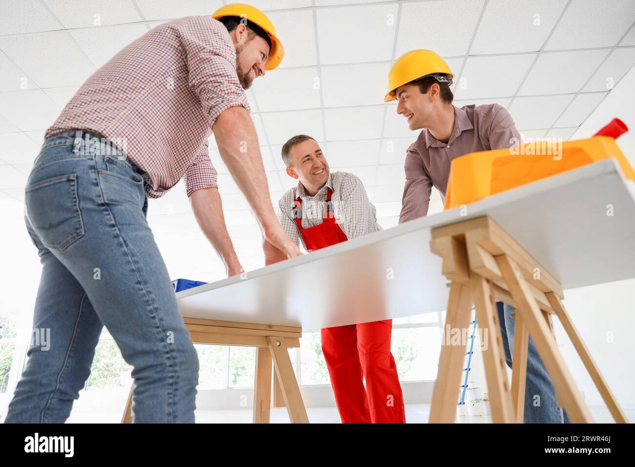 Team of male builders working at table in room Stock Photo