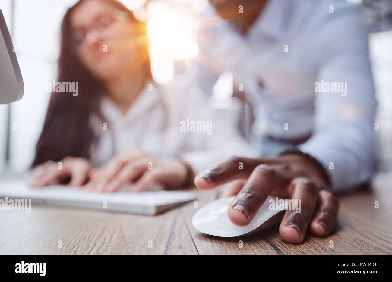 black man holding a computer mouse on the table, close-up Stock Photo