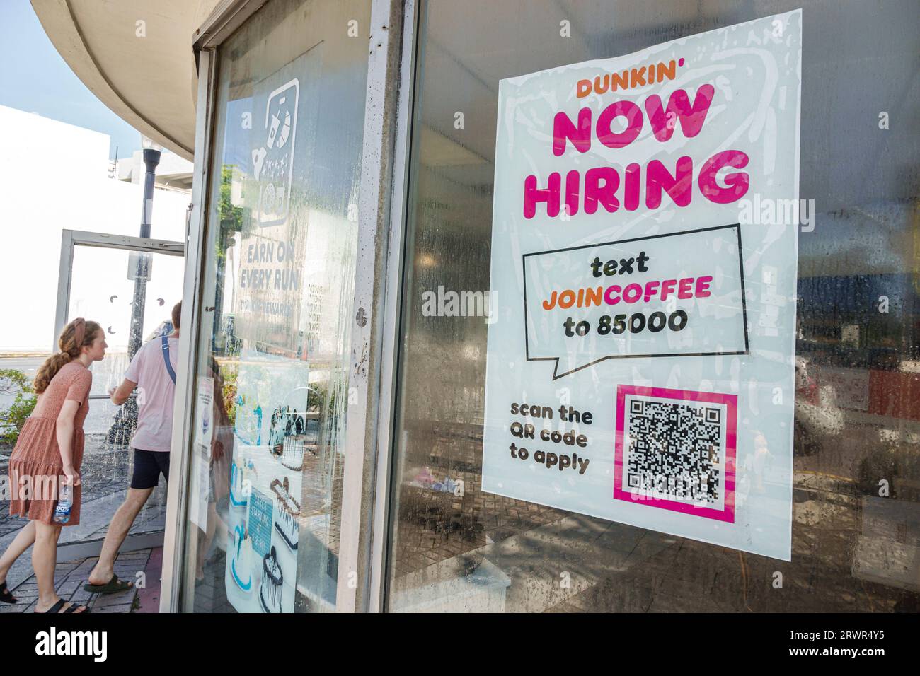 Miami Beach Florida,/Dunkin' Donuts sign,help wanted now hiring text scan QR code,economy workforce shortage,man men male,woman women lady female,adul Stock Photo