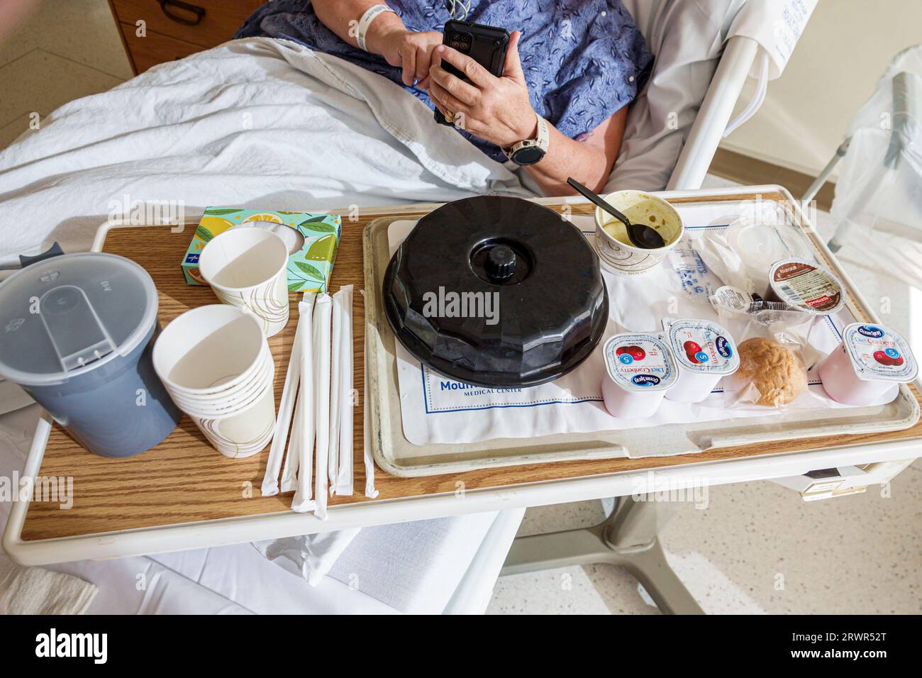 Miami Beach Florida,hospital patient room,bed table food meal lunch,woman women lady female,adult,using smartphone mobile cell phone,Hispanic Hispanic Stock Photo