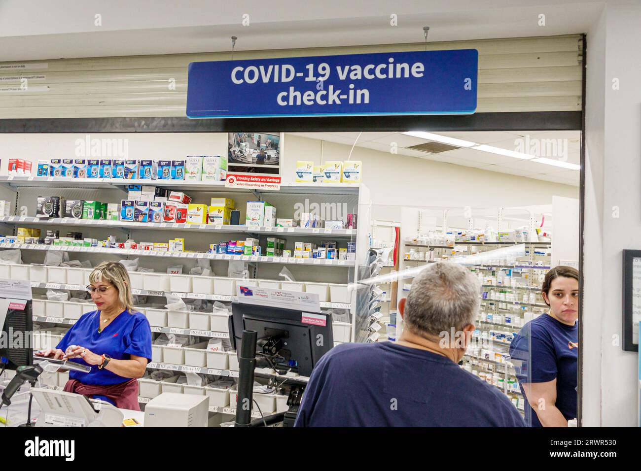 Miami Beach Florida,Walgreens Pharmacy drugstore,inside indoors interior,counter Covid-19 vaccine check-in coronavirus pandemic,man men male,woman wom Stock Photo
