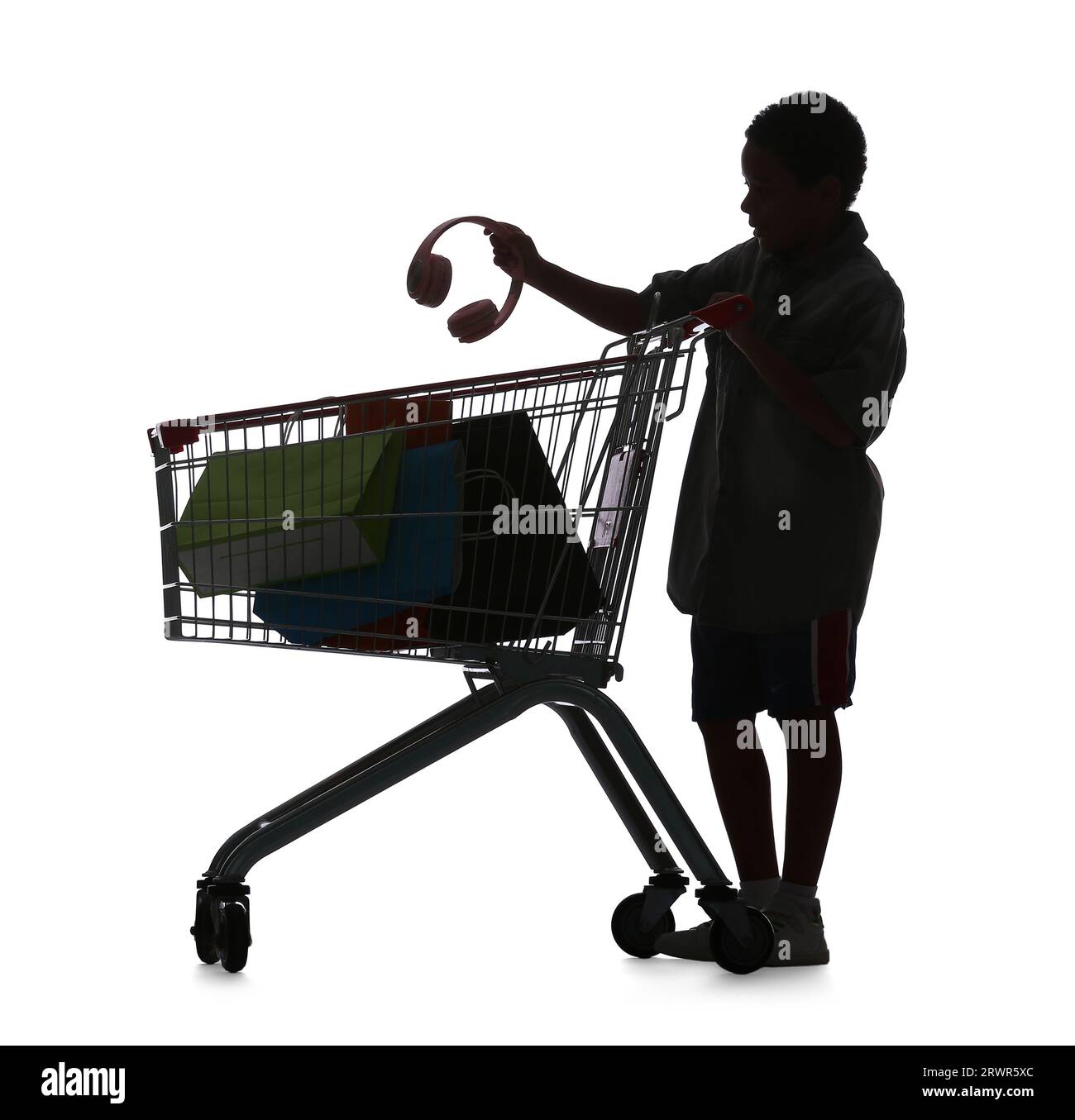 Silhouette of little boy with headphones and shopping cart on white background Stock Photo