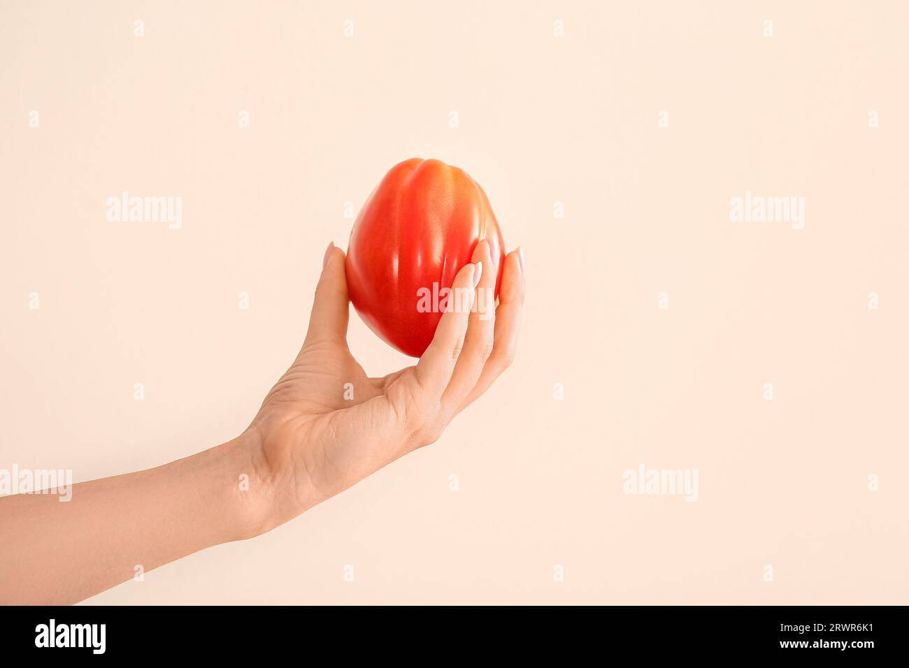 Female hand with fresh ripe tomato on white background Stock Photo - Alamy