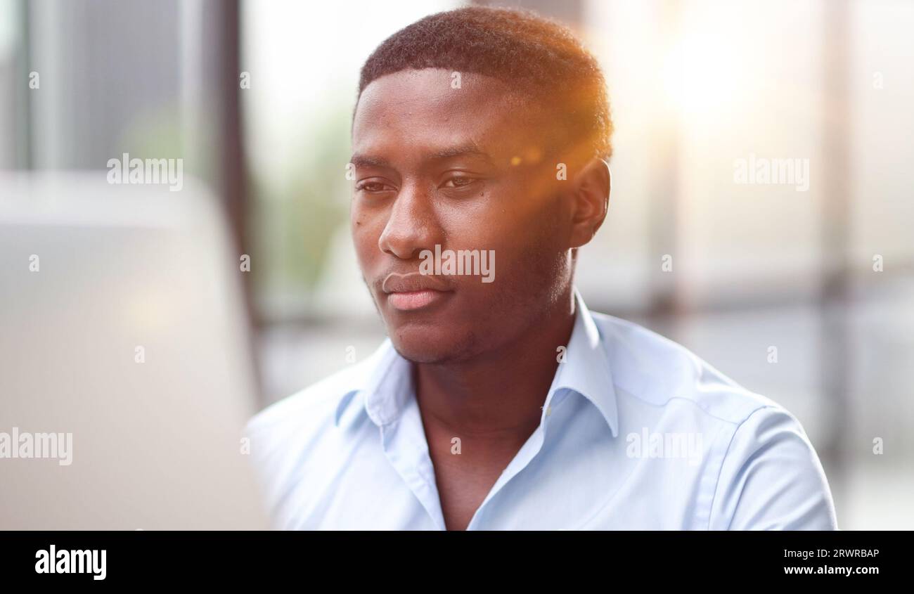 Thoughtful black man in eyeglasses stack with hard task, looking at computer screen, thinking of problem solution Stock Photo