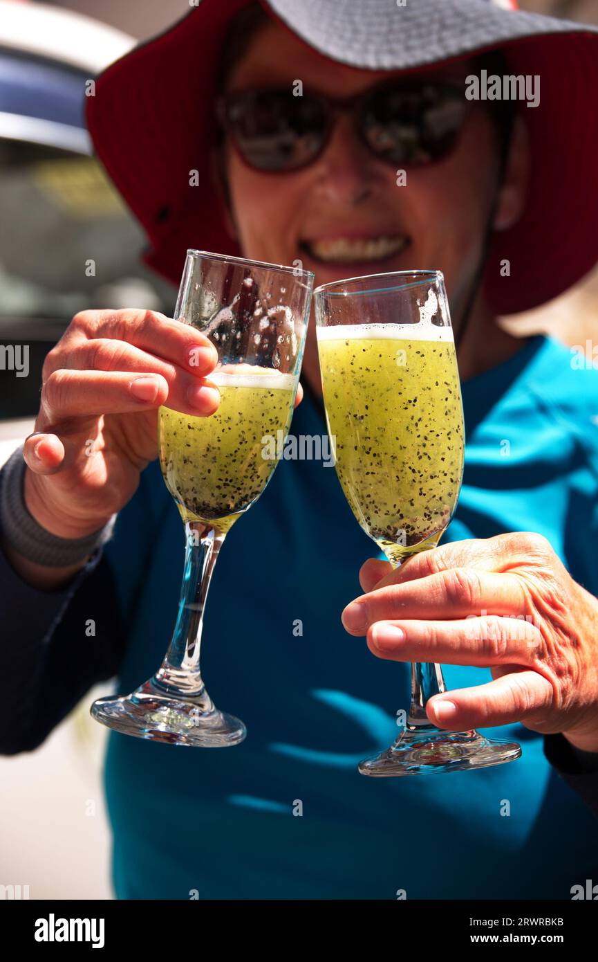 Senior woman holding two glasses of cactus juice in Peru Stock Photo