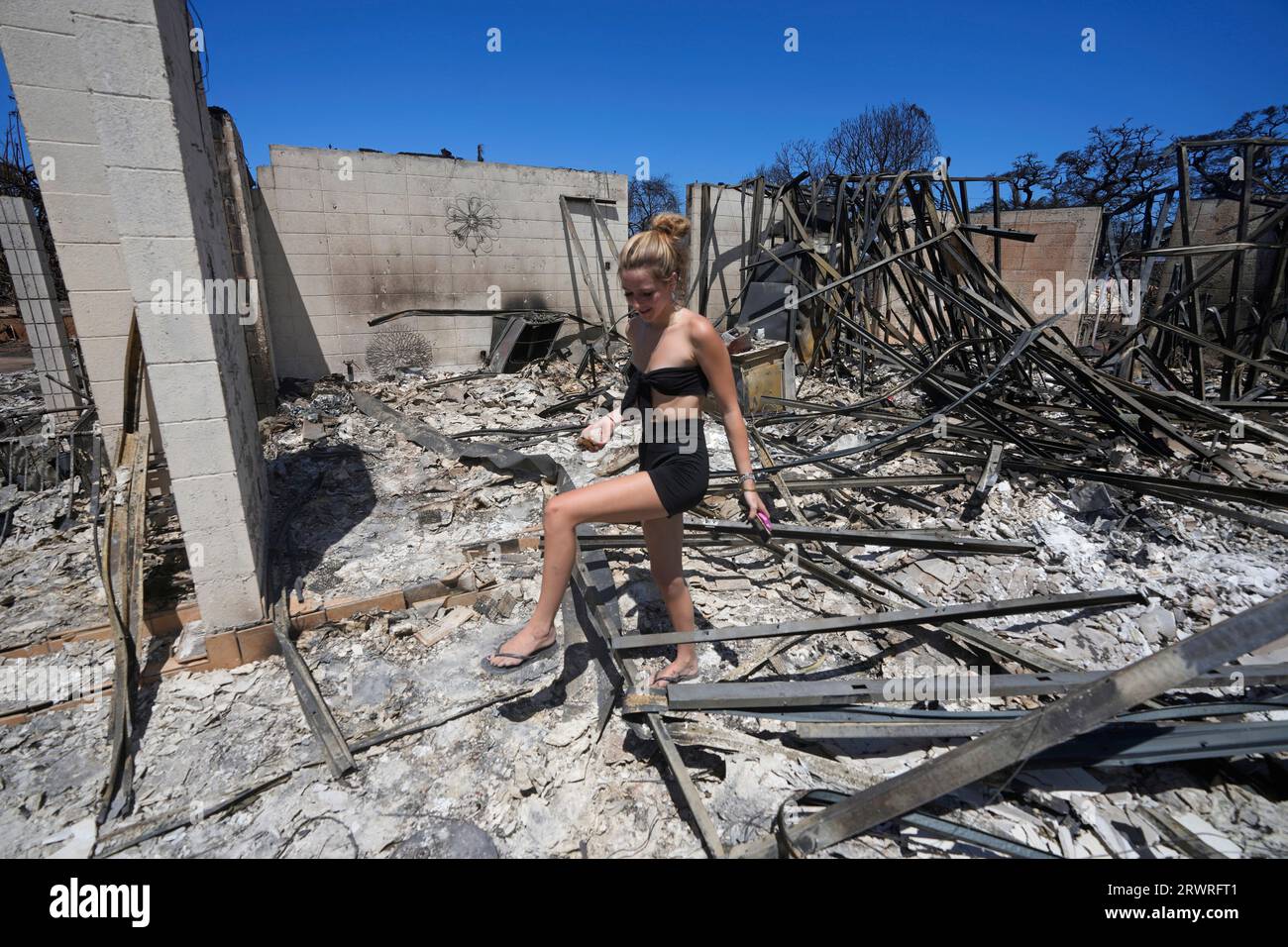 FILE - Sydney Carney walks through her home, which was destroyed by a  wildfire, Aug. 11, 2023, in Lahaina, Hawaii. Americans nationwide face  hefty increases in their homeowners insurance premiums in the