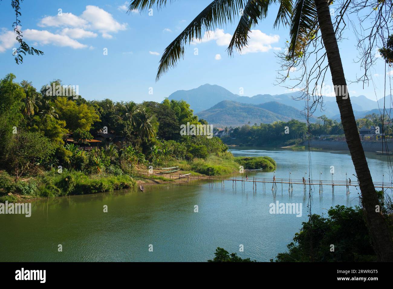 Laos: A bamboo bridge across the Nam Khan River, Luang Prabang. Luang Prabang was formerly the capital of a kingdom of the same name. Until the communist takeover in 1975, it was the royal capital and seat of government of the Kingdom of Laos. The city is nowadays a UNESCO World Heritage Site. Stock Photo