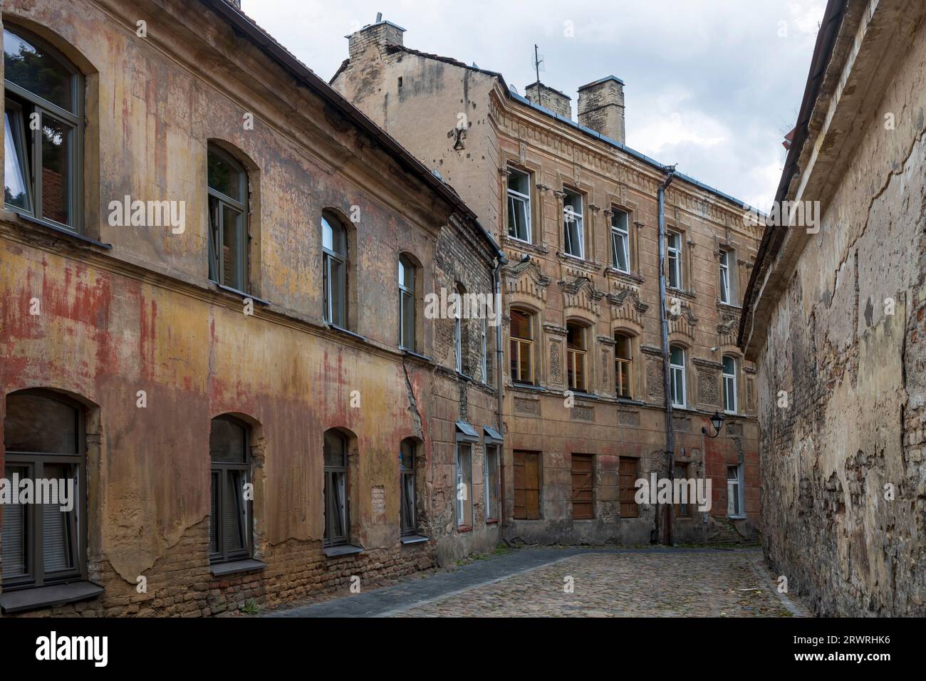 Vilnius, Lithuania - August 23, 2023,Abandoned dilapidated houses on a narrow empty street at dusk Stock Photo
