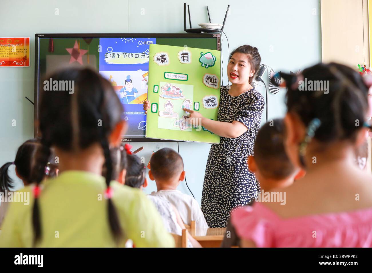 LUANNAN COUNTY, China - June 2, 2022: The kindergarten teacher explained the Chinese Dragon Boat Festival transmission customs to the children. Stock Photo