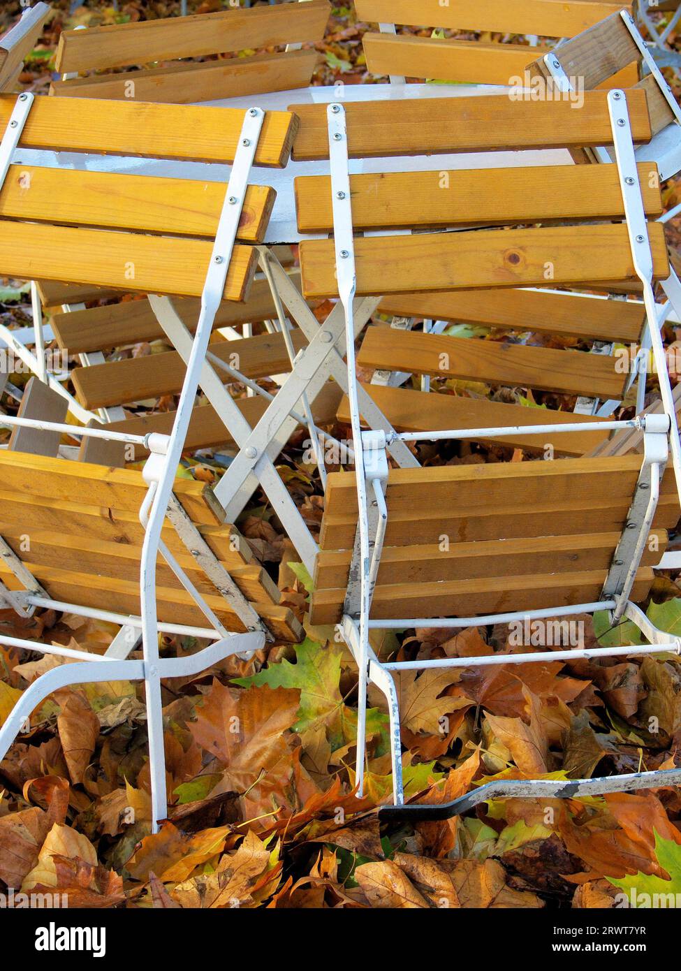 Wooden folding chairs, with water drops, around a white metal table