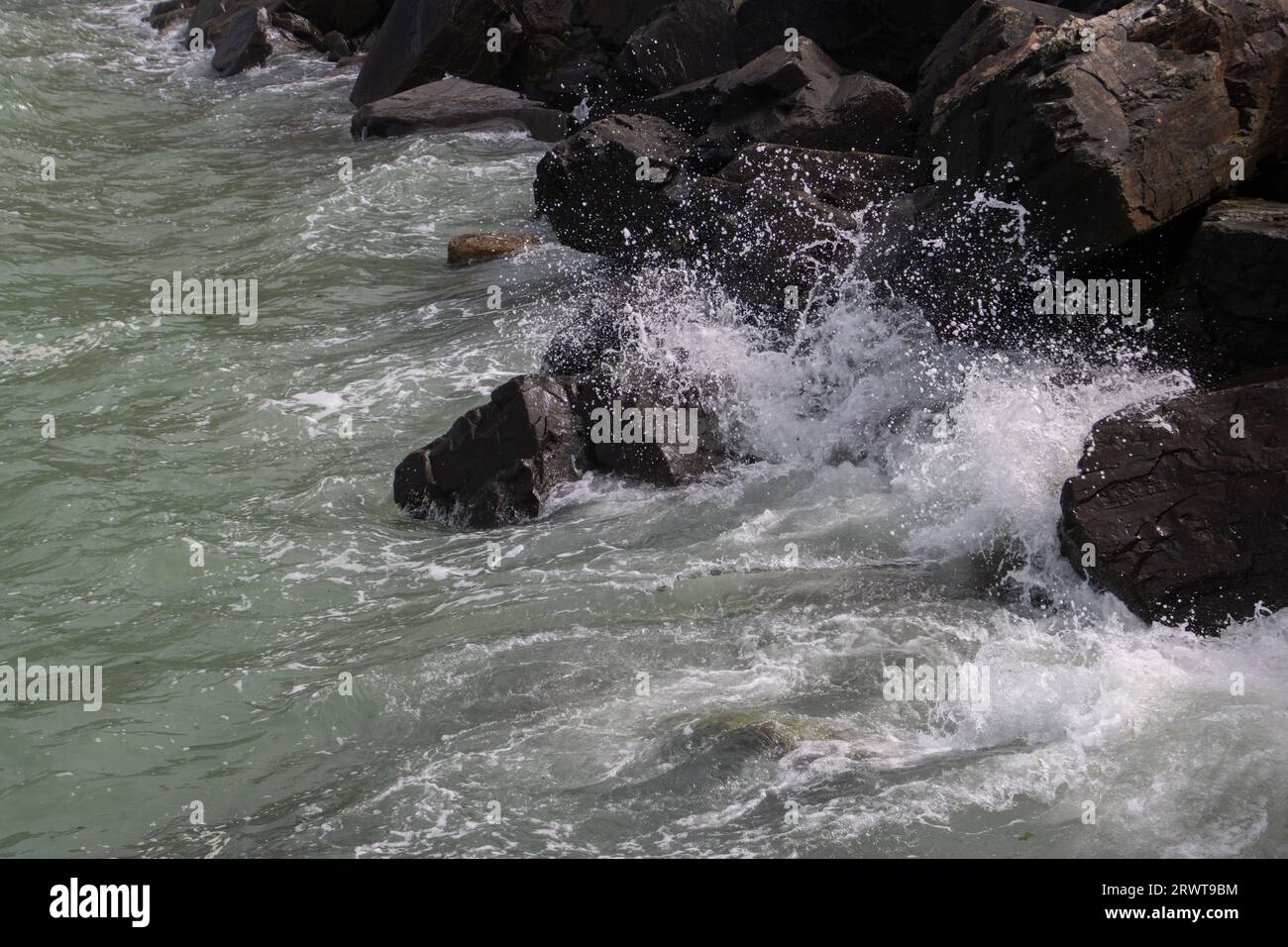 Aerial view of waves splashing on big rocks of a breakwater Stock Photo ...