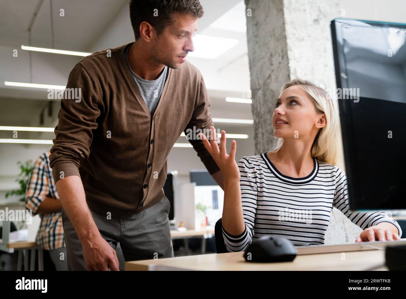 Working together on project. Two young business colleagues working together in startup office Stock Photo