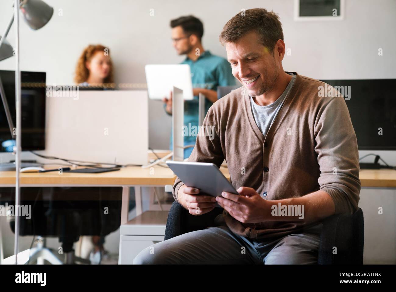 Confident and successful. Confident young man in startup business office holding digital tablet Stock Photo